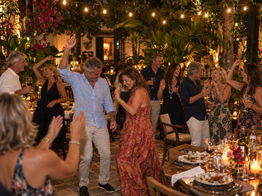 The cohort dancing under string lights at the farewell Tropical Night